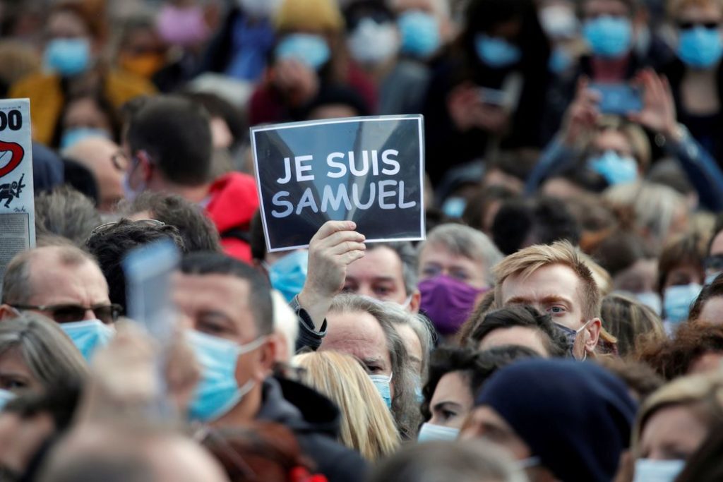 People gather at the Place de la Republique in Paris, to pay tribute to Samuel Paty, the French teacher who was beheaded on the streets of the Paris suburb of Conflans-Sainte-Honorine, France, October 18, 2020. Placard reads "I am a Samuel". REUTERS/Charles Platiau