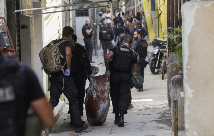 Policiais retiram um dos mortos na operação/Ricardo Moraes/Reuters