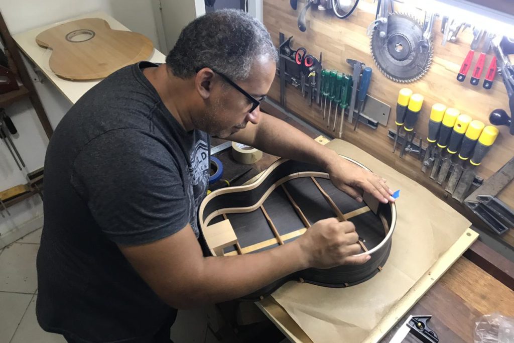 Davi Lopes faz acabamento em um dos instrumentos feitos por ele/Divulgação/Governo do RJ
