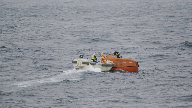 Guarda Costeira verificando um bote salva-vidas do cargueiro Jin Tian flutuando no mar/AFP / Japan Coast Guard